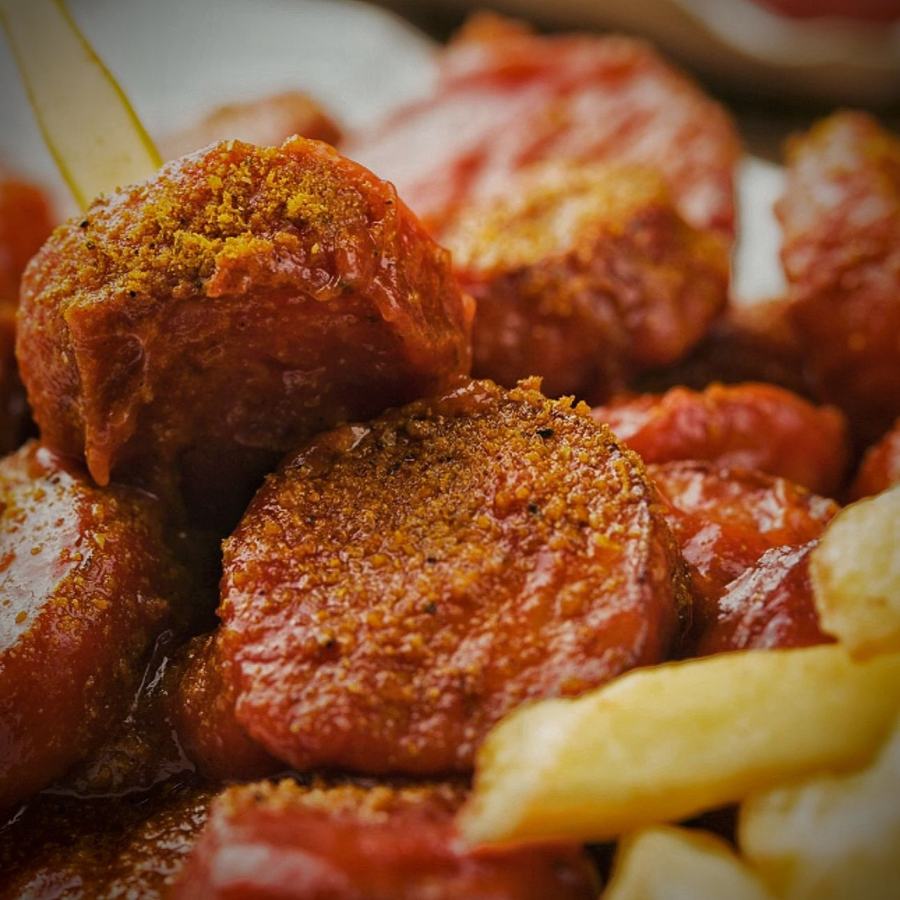 Close-up of currywurst with curry sauce and fries