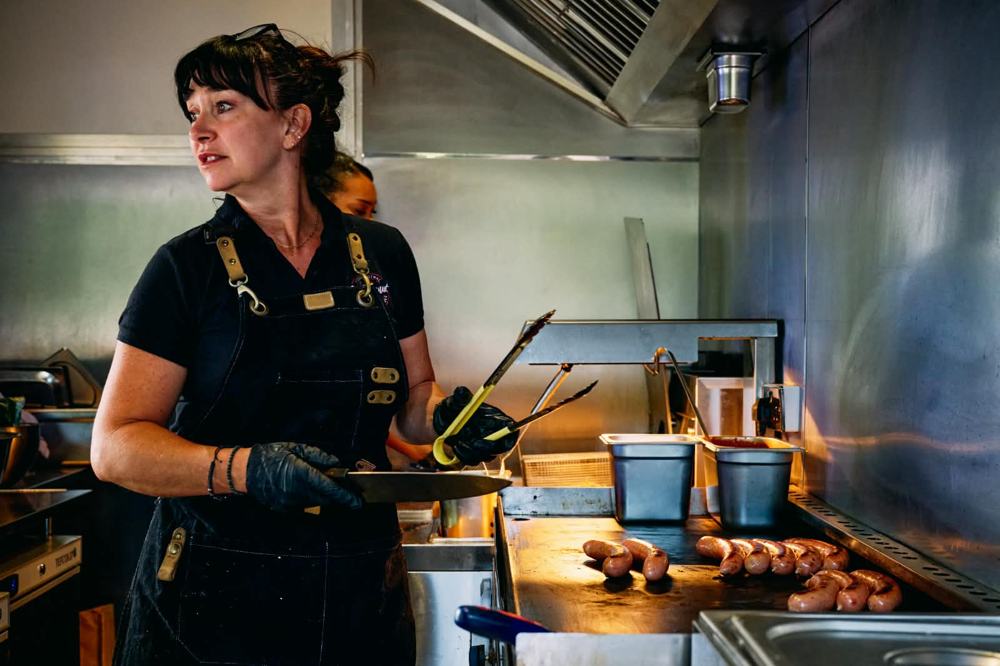 Founder Pia grilling sausages in the kitchen