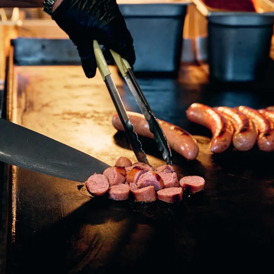 Bratwurst sliced on the grill